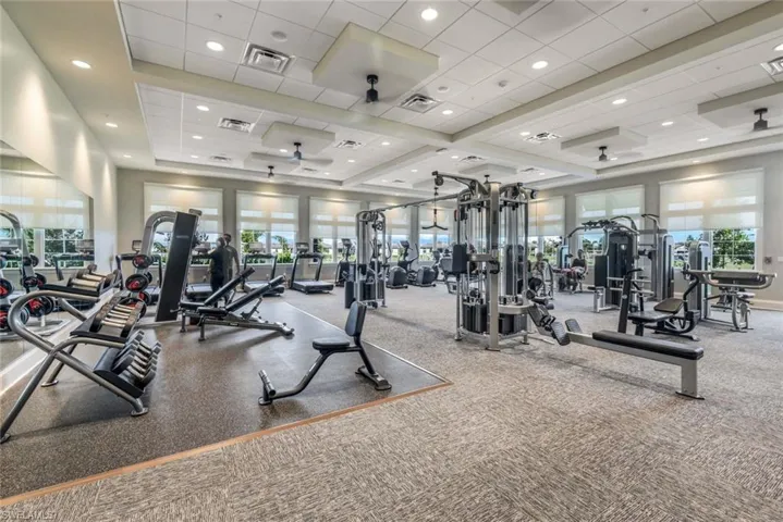 Exercise room featuring a tray ceiling and ceiling fan