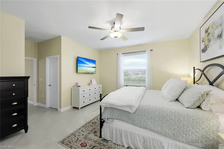 Bedroom with ceiling fan and light tile patterned floors