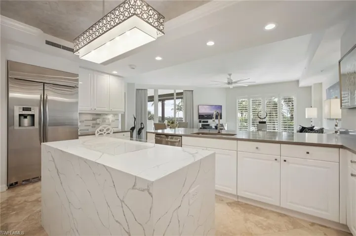 Kitchen featuring stainless steel appliances, white cabinetry, recessed lighting, tasteful backsplash, and a peninsula