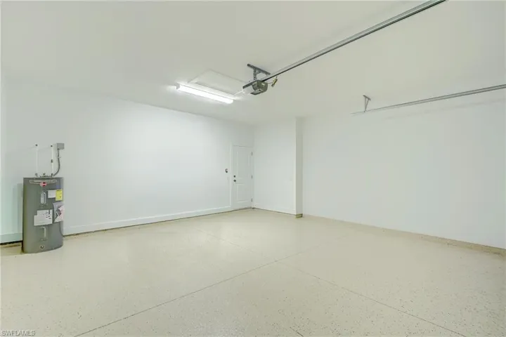 Unfurnished room with a raised ceiling, light wood-style flooring, a barn door, a ceiling fan, and recessed lighting