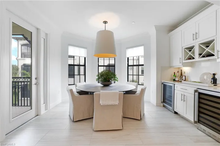 Dining room with wine cooler, crown molding, and a bar