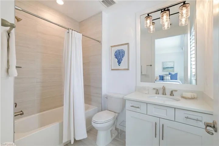 Full bath with vanity, shower / tub combo with curtain, and connected bathroom