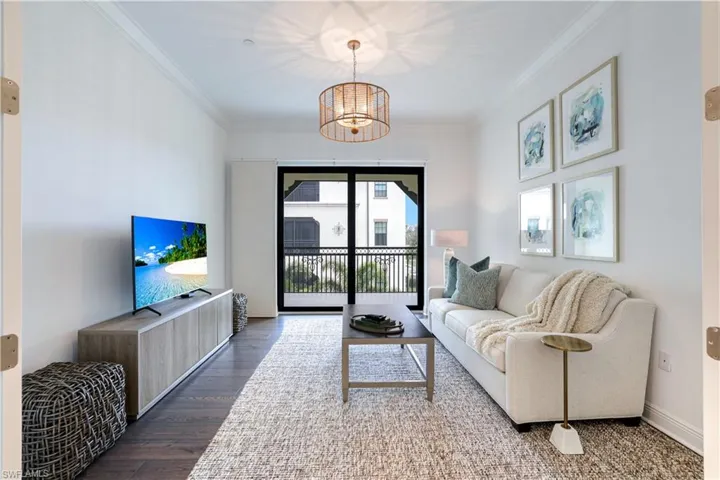 Living area with suspended lighting, crown molding, and wood finished floors