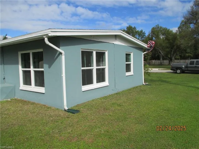 View of property exterior featuring stucco siding and a yard