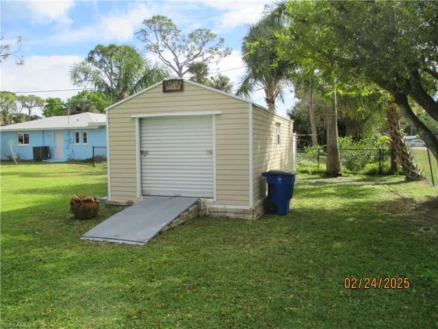 View of shed with central AC unit and fence