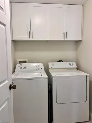 Laundry area featuring washer and dryer and cabinet space