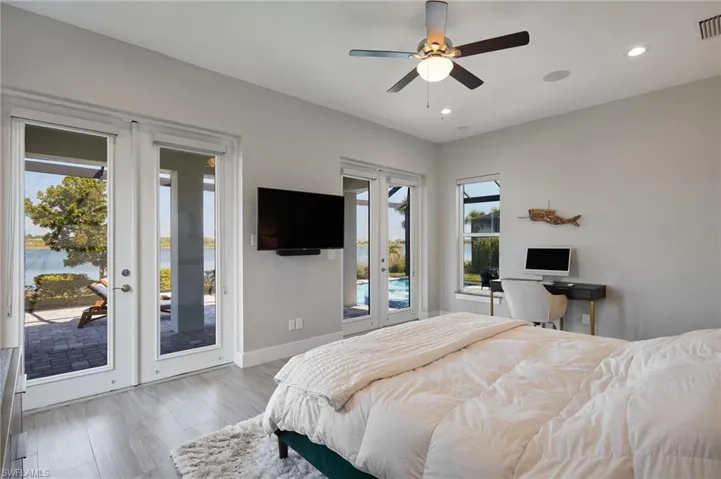 Bedroom with french doors, multiple windows, baseboards, and access to exterior