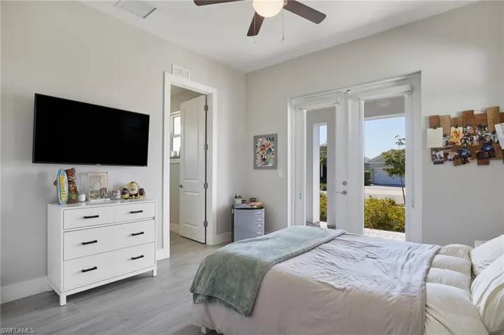 Bedroom featuring access to exterior, visible vents, light wood-style flooring, and baseboards