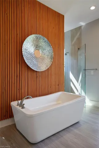 Full bath featuring recessed lighting, tiled shower, and a soaking tub