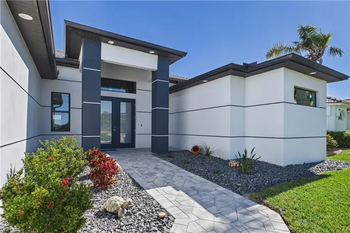 View of exterior entry featuring french doors and stucco siding