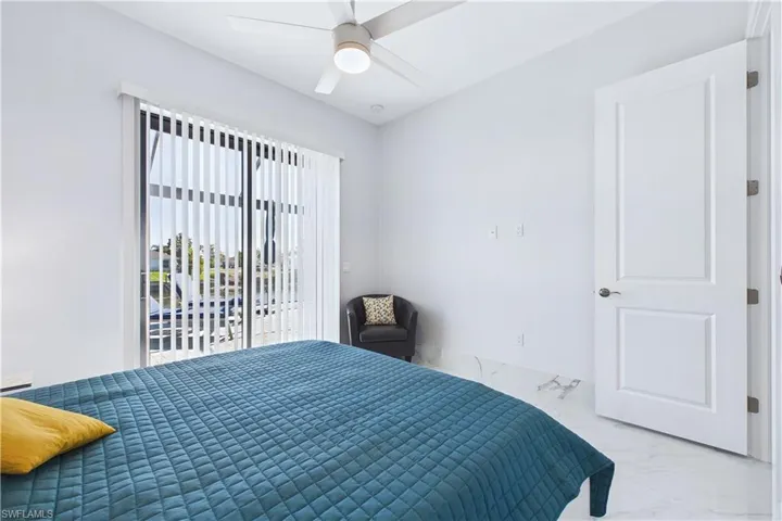 Bedroom with marble finish flooring, access to outside, and a ceiling fan