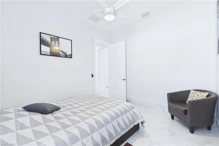 Bedroom with ceiling fan and marble finish floors