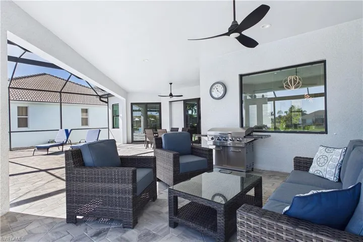 View of patio with a sunroom, a ceiling fan, a lanai, area for grilling, and an outdoor living / dining area