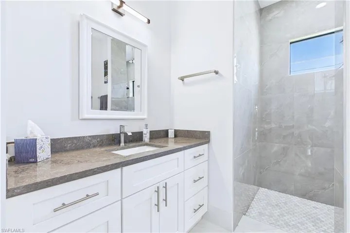 Full bathroom with a marble finish shower and vanity