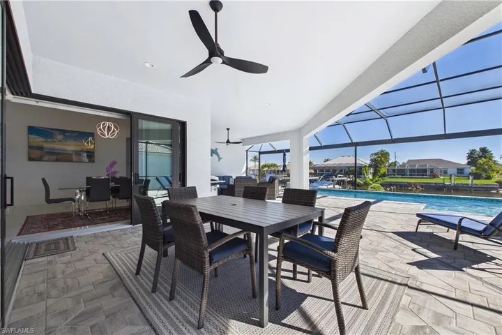 View of patio featuring an outdoor pool, outdoor dining space, a sunroom, a lanai, and a ceiling fan
