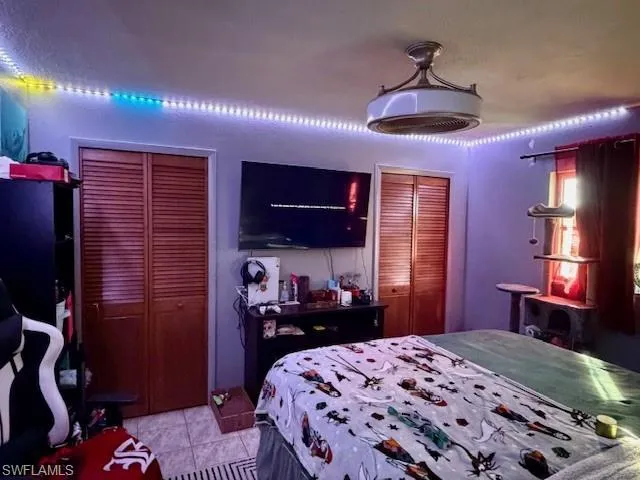 Bedroom featuring multiple closets and light tile patterned floors