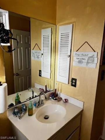 Bathroom with vanity and a textured wall