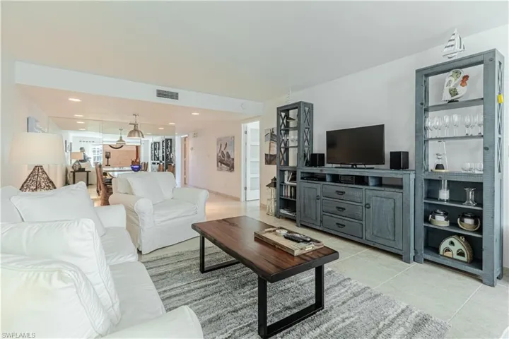 Living room with light tile patterned floors and recessed lighting