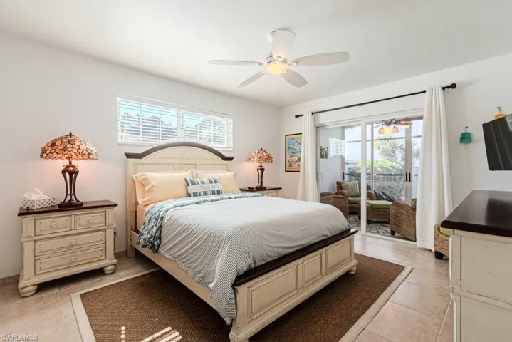 Bedroom featuring access to exterior, light tile patterned floors, and a ceiling fan