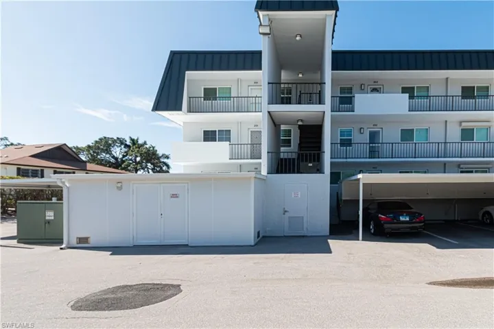 View of apartment building / complex with covered parking