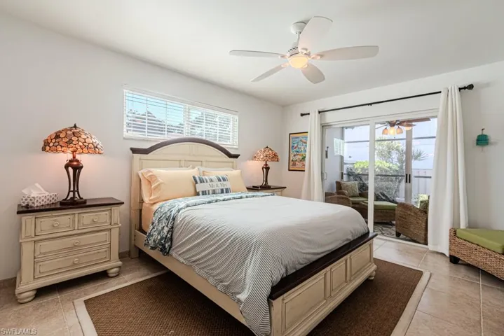 Bedroom with light tile patterned floors, access to outside, and ceiling fan