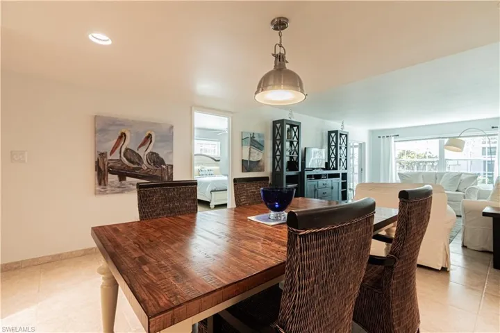 Dining space with light tile patterned flooring and recessed lighting