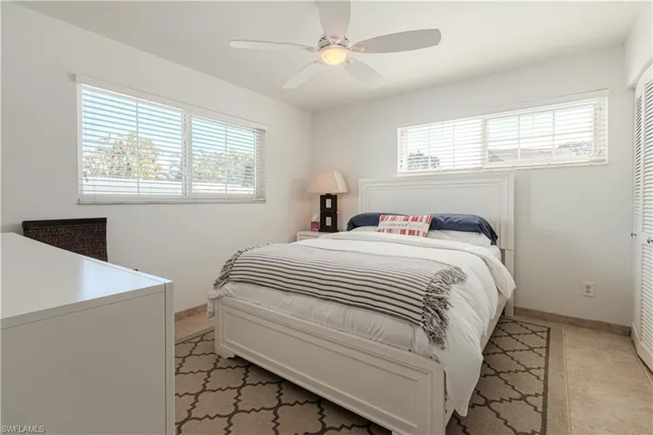 Bedroom featuring multiple windows, ceiling fan, and a closet