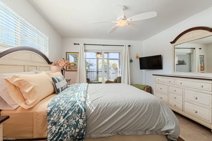 Bedroom featuring access to outside, ceiling fan, and light tile patterned flooring