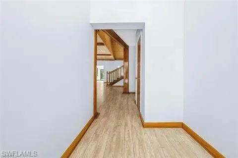 Hallway featuring light wood finished floors and stairs