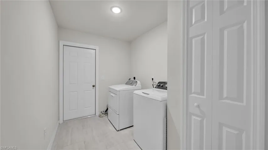 Laundry area featuring washer and dryer and baseboards