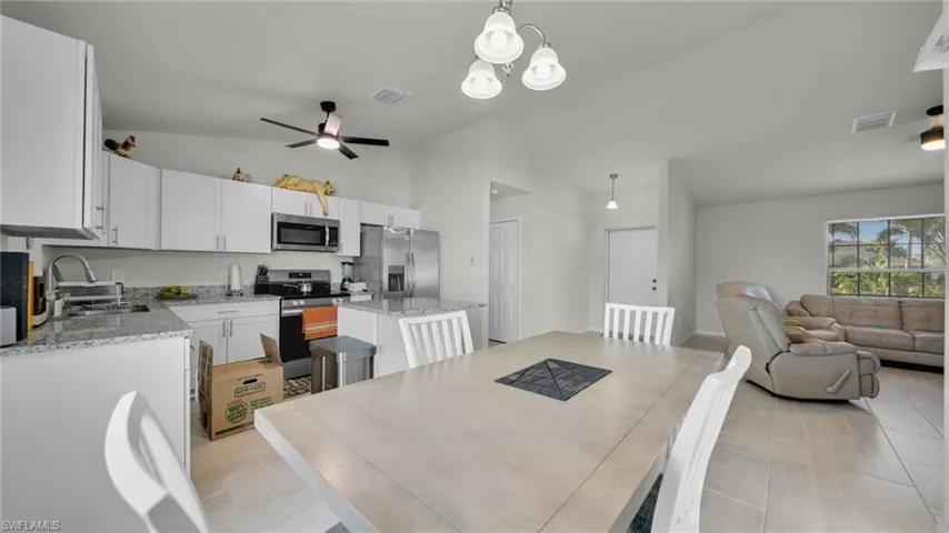 Dining space with lofted ceiling, ceiling fan, and a chandelier