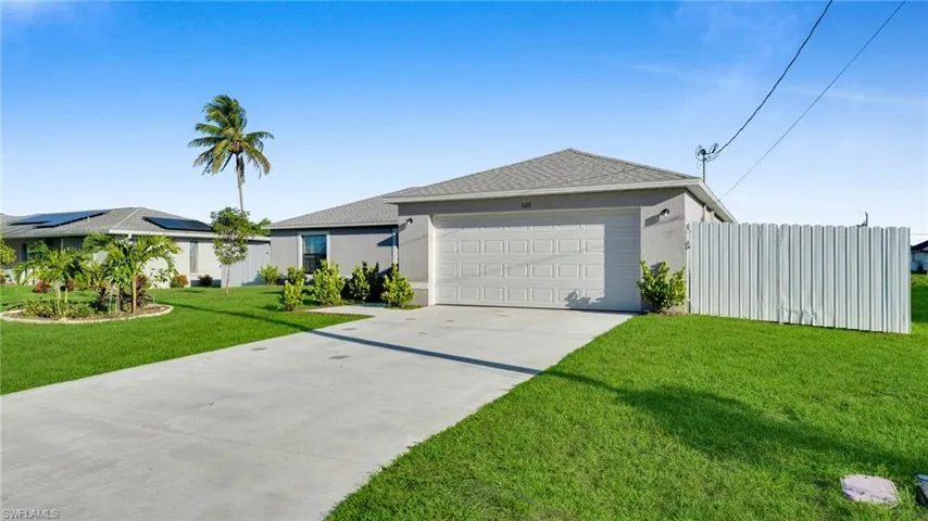 Single story home with driveway, a front lawn, stucco siding, roof with shingles, and an attached garage