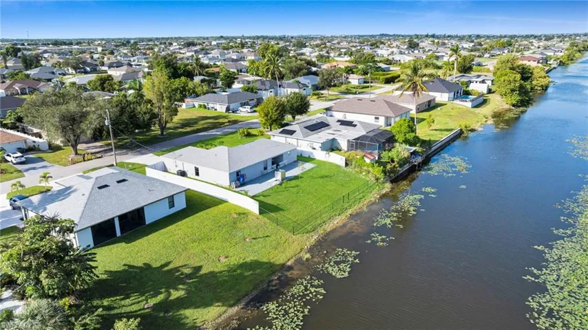 Aerial perspective of suburban area featuring a nearby body of water
