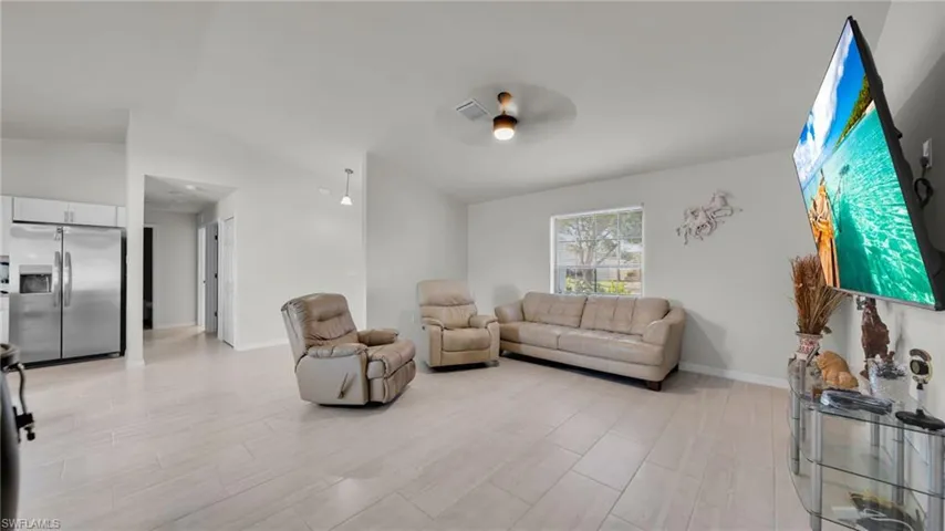 Living area with a ceiling fan and light wood-style flooring