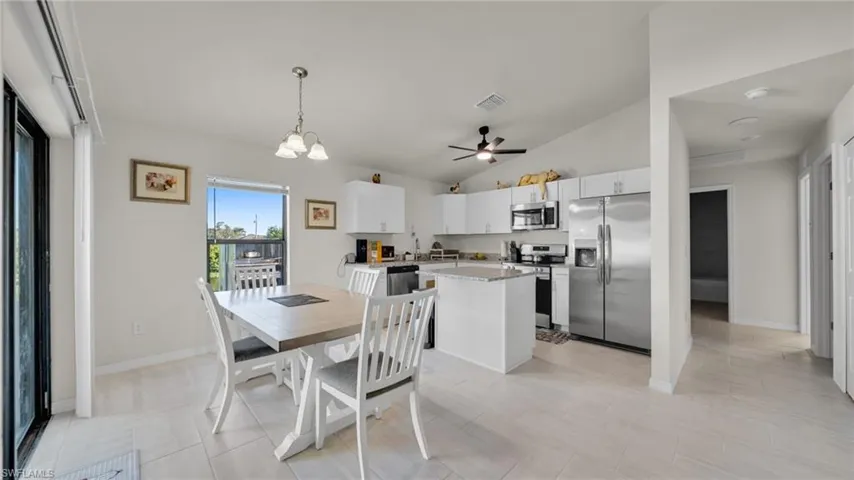 Dining room featuring lofted ceiling, a chandelier, and a ceiling fan