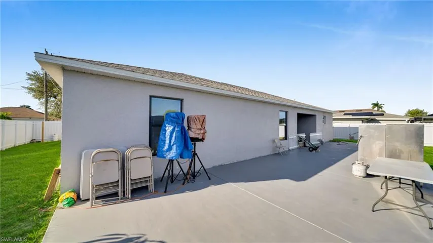 Back of property featuring a fenced backyard, stucco siding, a patio, and roof with shingles