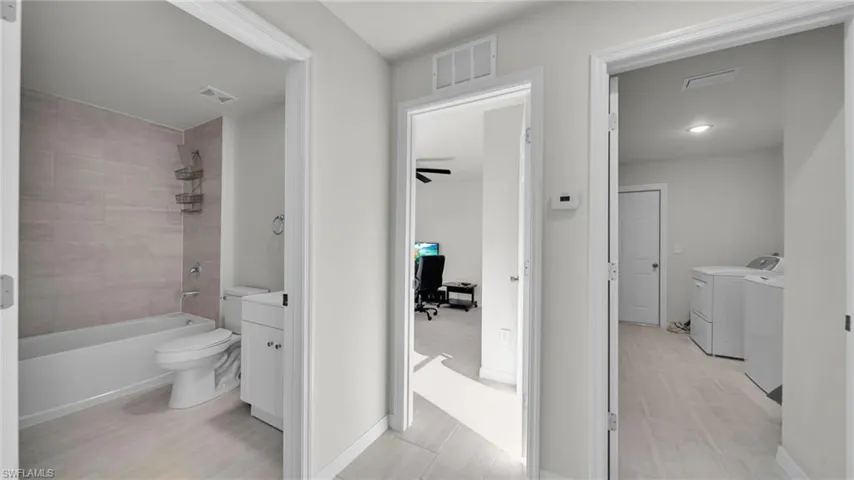 Full bath featuring tub / shower combination, washer and clothes dryer, light wood-type flooring, and vanity