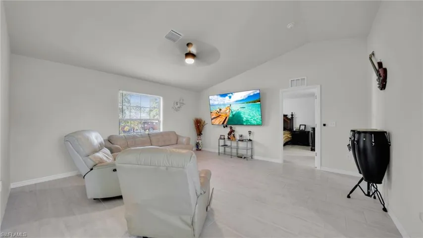 Living area featuring vaulted ceiling and a ceiling fan