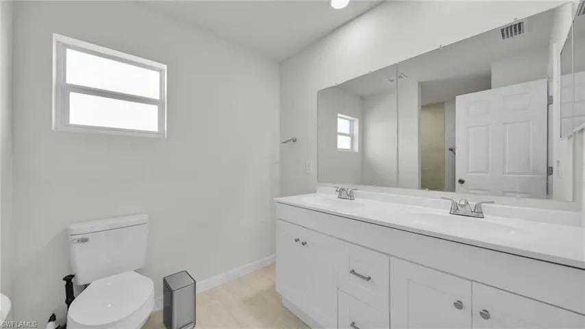 Bathroom featuring toilet and double vanity