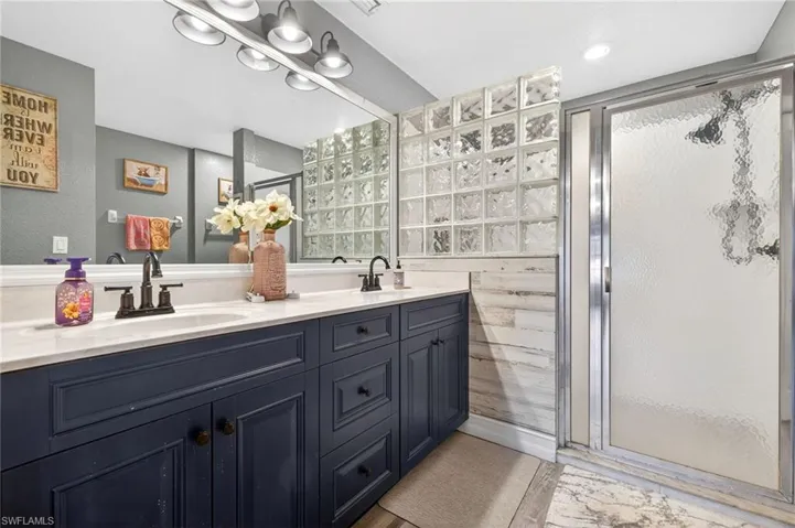 Primary Bathroom with double vanity and a stall shower