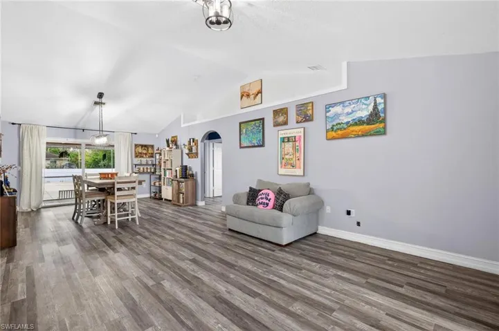 Living area featuring arched walkways and wood finished floors