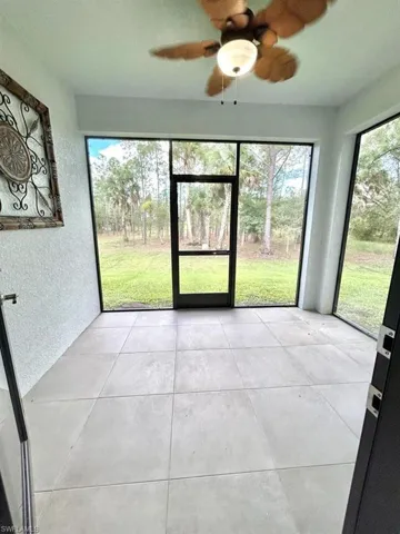 Unfurnished sunroom featuring a ceiling fan