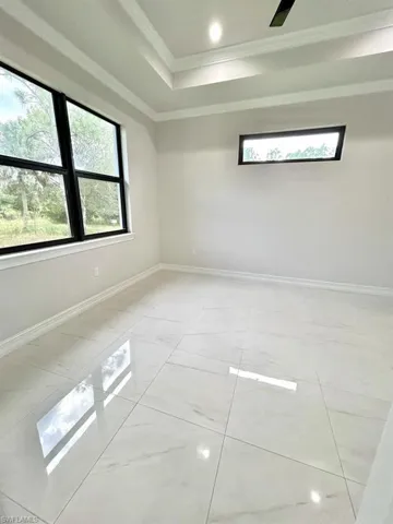 Unfurnished room featuring ornamental molding and a tray ceiling