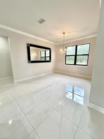Unfurnished room featuring a chandelier and ornamental molding