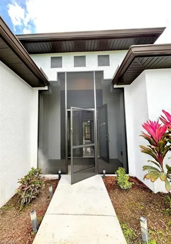 Property entrance with stucco siding and a sunroom