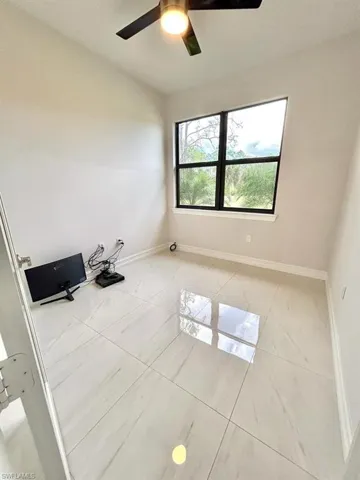 Spare room with baseboards and a ceiling fan