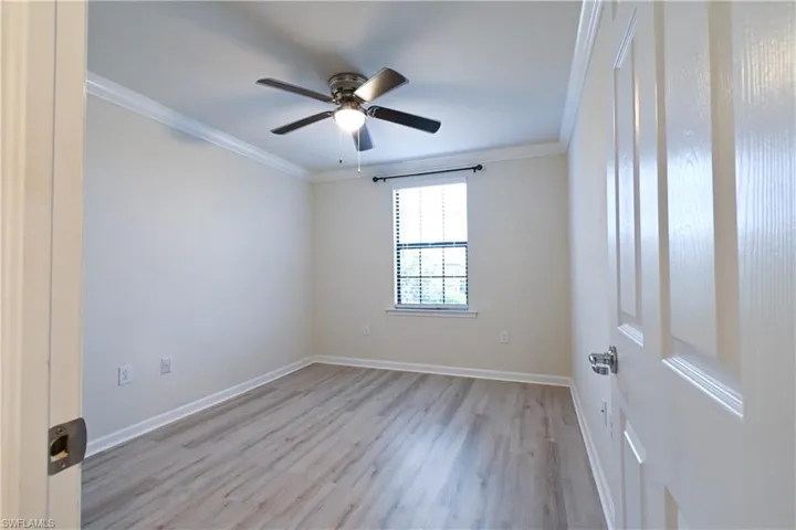 Empty room with light hardwood / wood-style flooring, ceiling fan, and ornamental molding