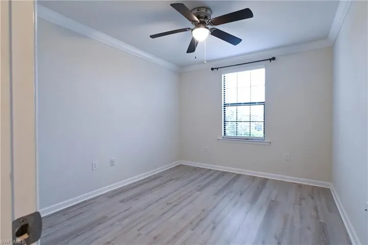 Empty room with ceiling fan, crown molding, and light hardwood / wood-style flooring
