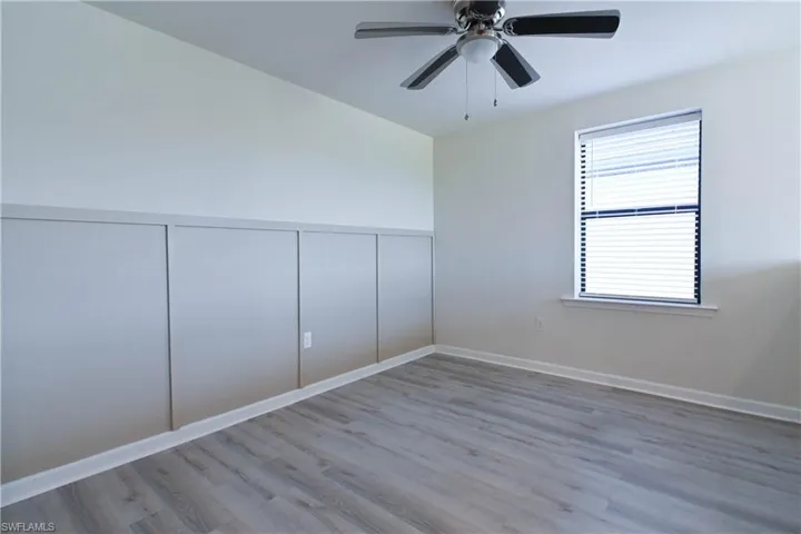 Empty room with ceiling fan and light hardwood / wood-style floors