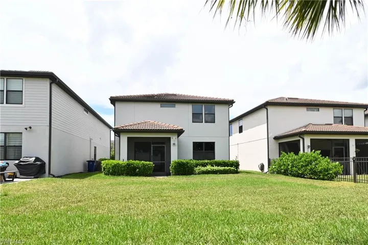 Back of property with a lawn